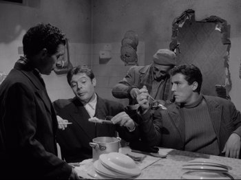 Movie still from “Big Deal on Madonna Street” (1958), directed by Mario Monicelli – A group of people sitting around a table; Medium shot, Low angle