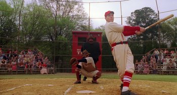 Movie still from “Big Fish” (2003), directed by Tim Burton – A man swinging a baseball bat on a field; Wide shot, Low angle