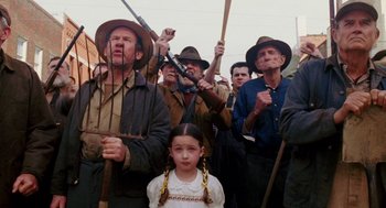 Movie still from “Big Fish” (2003), directed by Tim Burton – A group of men and a little girl holding guns; Medium shot, High angle