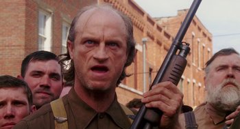 Movie still from “Big Fish” (2003), directed by Tim Burton – An old man with a beard holding a rifle; Close Up shot, Low angle