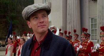 Movie still from “Big Fish” (2003), directed by Tim Burton – A man wearing a hat standing in front of a marching band; Close Up shot, Over the shoulder angle