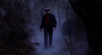 Movie still from “Big Fish” (2003), directed by Tim Burton – A man walking through the woods wearing a hat; Wide shot, Low angle