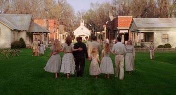 Movie still from “Big Fish” (2003), directed by Tim Burton – A group of people walking on a field of green grass; Wide shot, High angle