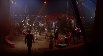 Movie still from “Big Fish” (2003), directed by Tim Burton – A group of people in a circus ring with elephants; Extreme Wide shot, High angle