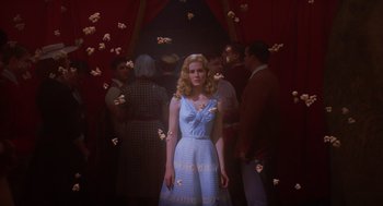 Movie still from “Big Fish” (2003), directed by Tim Burton – A woman standing in front of a group of people; Medium shot, Low angle