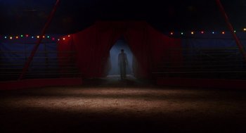 Movie still from “Big Fish” (2003), directed by Tim Burton – A man standing in front of a stage at night; Wide shot, Low angle