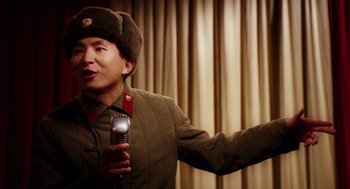 Movie still from “Big Fish” (2003), directed by Tim Burton – A man in a military uniform holding a cell phone in his hand; Medium shot, High angle