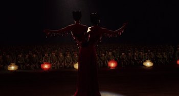 Movie still from “Big Fish” (2003), directed by Tim Burton – A couple of women standing next to each other in front of an audience; Wide shot, Over the shoulder angle