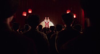 Movie still from “Big Fish” (2003), directed by Tim Burton – A couple of people standing in front of a crowd; Wide shot, Low angle