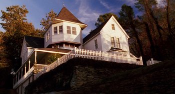 Movie still from “Big Fish” (2003), directed by Tim Burton – A white house with a white picket fence on top of a hill; Extreme Wide shot, Low angle