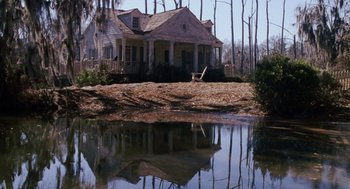 Movie still from “Big Fish” (2003), directed by Tim Burton – A house sitting next to a body of water; Extreme Wide shot, High angle