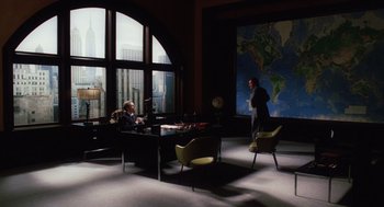 Movie still from “Big Fish” (2003), directed by Tim Burton – Two people sitting at a table in front of a large map; Wide shot, High angle