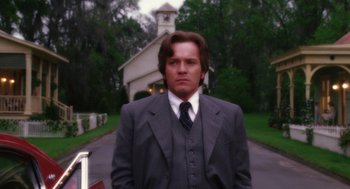 Movie still from “Big Fish” (2003), directed by Tim Burton – A man in a suit and tie standing in front of a church; Close Up shot, Low angle