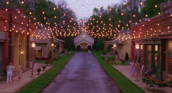 Movie still from “Big Fish” (2003), directed by Tim Burton – A couple of people walking down a street; Extreme Wide shot, High angle