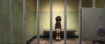 Movie still from “Big Hero 6” (2014), directed by Chris Williams – A person sitting on a bench in a jail cell; Wide shot, Overhead angle