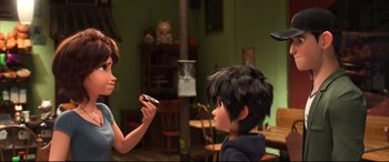 Movie still from “Big Hero 6” (2014), directed by Chris Williams – A woman is holding a cookie and a boy is eating it; Medium shot, Over the shoulder angle