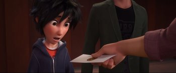 Movie still from “Big Hero 6” (2014), directed by Chris Williams – A person handing a piece of paper to a boy; Close Up shot, Over the shoulder angle