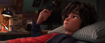 Movie still from “Big Hero 6” (2014), directed by Chris Williams – A person sitting on a couch holding a cell phone; Close Up shot, High angle