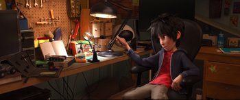 Movie still from “Big Hero 6” (2014), directed by Chris Williams – A boy sitting at a desk in front of a desk lamp; Medium shot, High angle