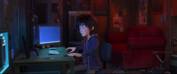 Movie still from “Big Hero 6” (2014), directed by Chris Williams – A person sitting in front of a computer on top of a table; Medium shot, High angle
