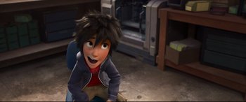 Movie still from “Big Hero 6” (2014), directed by Chris Williams – A person sitting on the ground in a room; Medium shot, High angle