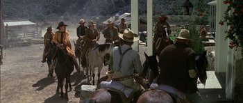 Movie still from “Big Jake” (1971), directed by George Sherman – A group of men on horses in a field; Wide shot, Over the shoulder angle