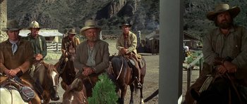 Movie still from “Big Jake” (1971), directed by George Sherman – A group of men sitting on top of a horse; Wide shot, Low angle