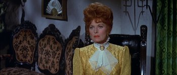 Movie still from “Big Jake” (1971), directed by George Sherman – An older woman in a yellow dress with a white collar; Close Up shot, Over the shoulder angle