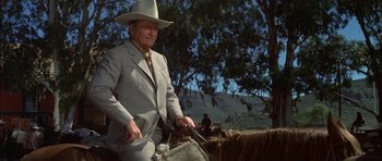 Movie still from “Big Jake” (1971), directed by George Sherman – An older man in a cowboy hat is riding a horse; Medium shot, Low angle