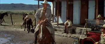 Movie still from “Big Jake” (1971), directed by George Sherman – A man riding on the back of a brown horse; Wide shot, Low angle