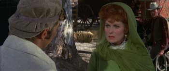 Movie still from “Big Jake” (1971), directed by George Sherman – A man and a woman are talking in a rural setting; Close Up shot, Over the shoulder angle