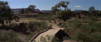 Movie still from “Big Jake” (1971), directed by George Sherman – A group of people riding horses down a path; Extreme Wide shot, High angle