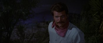 Movie still from “Big Jake” (1971), directed by George Sherman – A man with a mustache wearing a pink bandana; Close Up shot, Over the shoulder angle