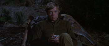 Movie still from “Big Jake” (1971), directed by George Sherman – A man holding a cup sitting in a chair; Close Up shot, High angle