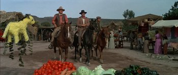 Movie still from “Big Jake” (1971), directed by George Sherman – A group of men riding on the backs of horses; Wide shot, Low angle