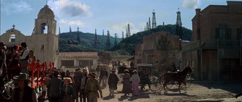Movie still from “Big Jake” (1971), directed by George Sherman – A group of people standing in a dirt field; Extreme Wide shot, High angle