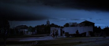 Movie still from “Big Jake” (1971), directed by George Sherman – Two people riding horses on a dirt road at night; Extreme Wide shot, Low angle