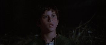 Movie still from “Big Jake” (1971), directed by George Sherman – A young boy is looking up at the sky; Close Up shot, Low angle