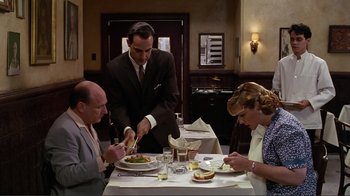 Movie still from “Big Night” (1996), directed by Stanley Tucci – A group of people sitting at a table with plates of food; Medium shot, High angle