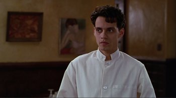 Movie still from “Big Night” (1996), directed by Stanley Tucci – A man in a white shirt is standing in a room; Close Up shot, Low angle