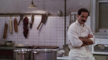 Movie still from “Big Night” (1996), directed by Stanley Tucci – A man standing in a kitchen next to pots and pans; Medium shot, Low angle