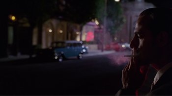 Movie still from “Big Night” (1996), directed by Stanley Tucci – A man smoking a cigarette on the side of the road; Extreme Close Up shot, Over the shoulder angle