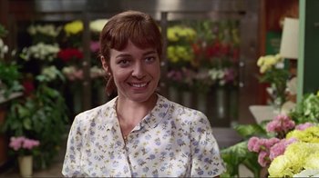 Movie still from “Big Night” (1996), directed by Stanley Tucci – A woman in a floral shirt smiling for the camera; Close Up shot, Low angle