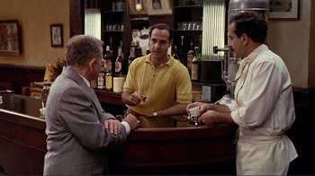 Movie still from “Big Night” (1996), directed by Stanley Tucci – A group of men standing around a bar; Wide shot, Over the shoulder angle
