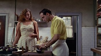 Movie still from “Big Night” (1996), directed by Stanley Tucci – A man and a woman in a kitchen preparing a meal; Medium shot, Low angle