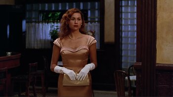 Movie still from “Big Night” (1996), directed by Stanley Tucci – A woman wearing gloves and holding a purse; Medium shot, Low angle