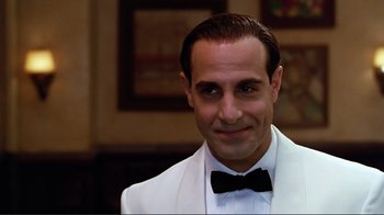 Movie still from “Big Night” (1996), directed by Stanley Tucci – A person wearing a suit and a bow tie; Close Up shot, Over the shoulder angle