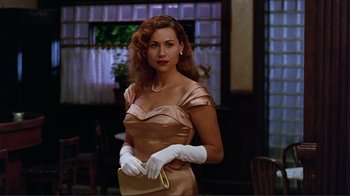 Movie still from “Big Night” (1996), directed by Stanley Tucci – A woman in a satin dress holding a white purse; Medium shot, Low angle