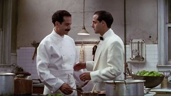 Movie still from “Big Night” (1996), directed by Stanley Tucci – Two men in a kitchen talking to each other; Medium shot, Over the shoulder angle