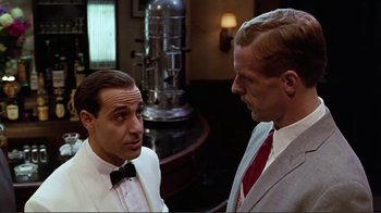 Movie still from “Big Night” (1996), directed by Stanley Tucci – A man in a suit and tie talking to another man in a suit and tie; Medium shot, Over the shoulder angle